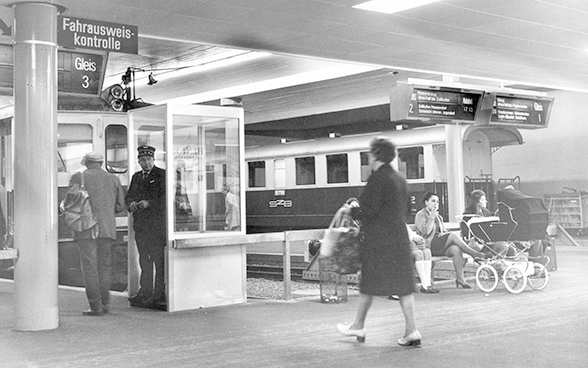 Voyageurs et contrôleur de billets dans la gare RBS à Berne dans les années 1960